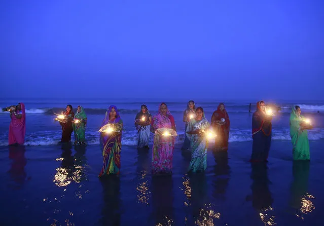 Hindu devotees pray while standing in the waters of the Arabian Sea as they worship the Sun god Surya during the Hindu religious festival Chatt Puja in Mumbai October 30, 2014. (Photo by Danish Siddiqui/Reuters)