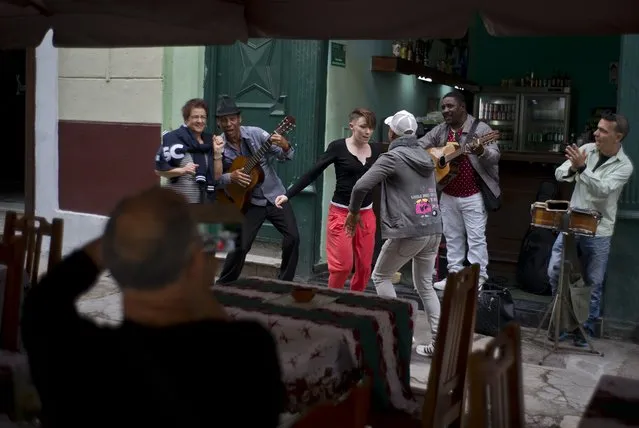 In this January 17, 2018 photo, tourists dance as musicians play on a bar in Havana, Cuba. The number of American travelers rose to 619,000, more than six times the pre-Obama level. But amid the boom, an 18 percent increase over 2016, owners of private restaurants and bed-and-breakfasts are reporting a sharp drop-off. (Photo by Ramon Espinosa/AP Photo)