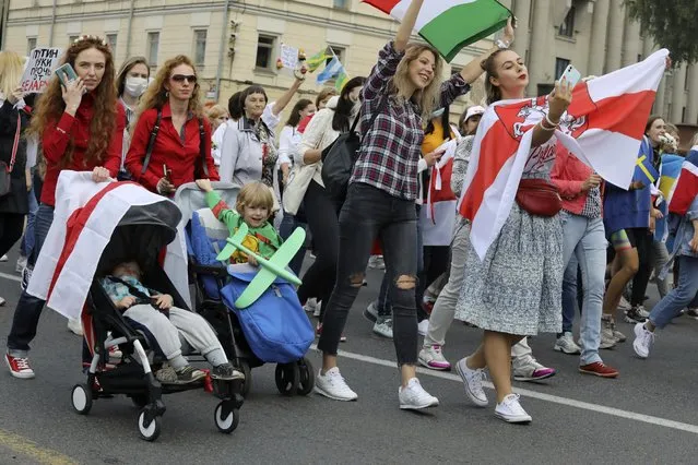 Women with old Belarusian national flags and their kids march during an opposition rally to protest the official presidential election results in Minsk, Belarus, Saturday, September 5, 2020. Women's marches and demonstrations have become a regular feature of the four weeks of protest that have shaken Belarus following a disputed election that gave Belarusian President Alexander Lukashenko a sixth term in office. (Photo by AP Photo/Stringer)