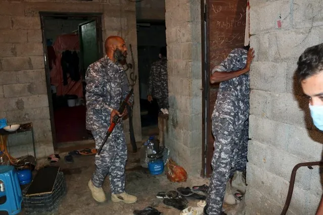 Officers of a Libyan anti-illegal immigrants unit conduct an early morning raid on migrants at hideout in Tripoli, Libya October 13, 2015. (Photo by Hani Amara/Reuters)