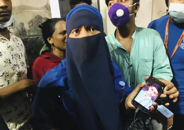 A woman shows a photograph of her young boy who has gone missing after a gas pipeline explosion, at a hospital in Dhaka, Bangladesh, Saturday, September 5, 2020. An underground gas pipeline near a mosque exploded during evening prayers outside the capital of Bangladesh, leaving at least 11 Muslim worshipers dead and dozens injured with critical burns, officials said Saturday. The blast occurred Friday night as people were finishing their prayers at Baitus Salat Jame Mosque at Narayanganj, local police chief Zayedul Alam said. (Photo by Al-emrun Garjon/AP Photo)