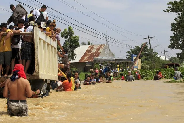 Residents climb on a truck while they wade in flood waters brought by typhoon Koppu that battered Candaba town, Pampanga province, north of Manila October 20, 2015. (Photo by Romeo Ranoco/Reuters)