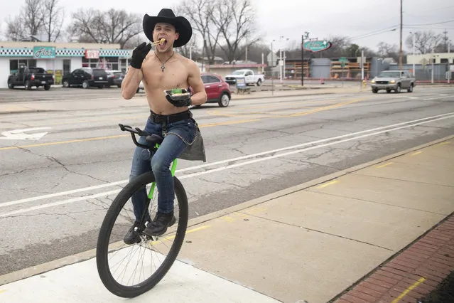 Josiah Ferrill rides his unicycle down East 11th Street while eating sushi on Wednesday, January 24, 2023, in Tulsa, Okla. (Photo by Daniel Shular/Tulsa World via AP Photo)