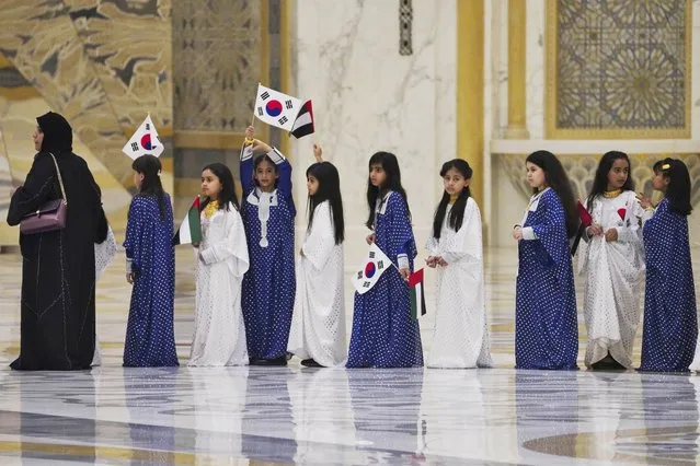 Emirati school girls prepare to greet South Korean President Yoon Suk Yeol at Qasar Al Watan in Abu Dhabi, United Arab Emirates, Sunday, January 15, 2023. South Korean President Yoon Suk Yeol received an honor guard welcome Sunday on a trip to the United Arab Emirates, where Seoul hopes to expand its military sales while finishing its construction of the Arabian Peninsula's first nuclear power plant. (Photo by Jon Gambrell/AP Photo)