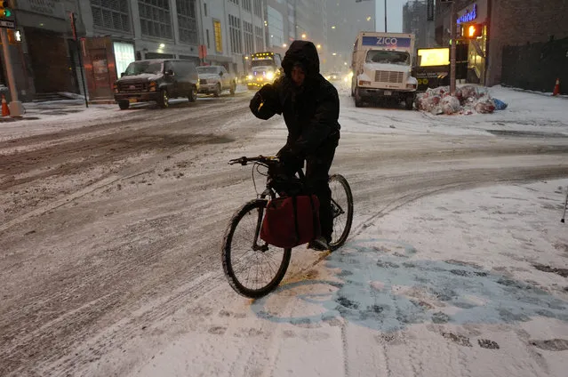A bicyclist maneuvers through an early morning snowfall, Thursday, January 4, 2018, in New York. Residents across a huge swath of the U.S. awakened Thursday to the beginnings of a massive winter storm expected to deliver snow, ice and high winds followed by possible record-breaking cold as it moves up the Eastern Seaboard from the Carolinas to Maine. (Photo by Mark Lennihan/AP Photo)