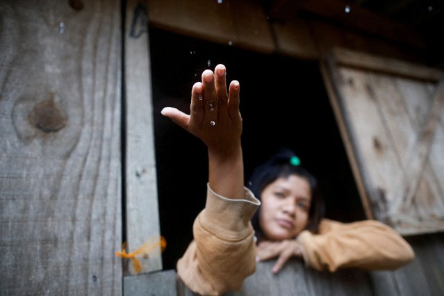 Pailona Ramirez from Guarani people looks on during rain at Pindo Poty village after it was flooded, in Porto Alegre, Rio Grande do Sul state, Brazil on May 13, 2024. (Photo by Adriano Machado/Reuters)