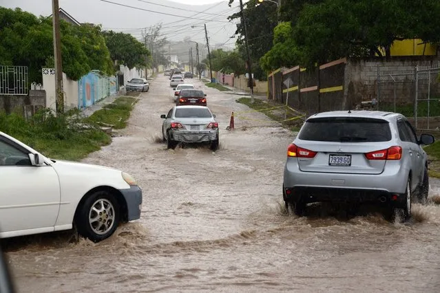 Vehicles drive along a flooded street due to heavy rains brought by hurricane Matthew in Kingston, Jamaica, 02 October 2016. Hurricane Matthew is continuing its path trough the Caribbean, with hurricane alerts issued in Jamaica, Haiti and Cuba. (Photo by Rudolph Brown/EPA)