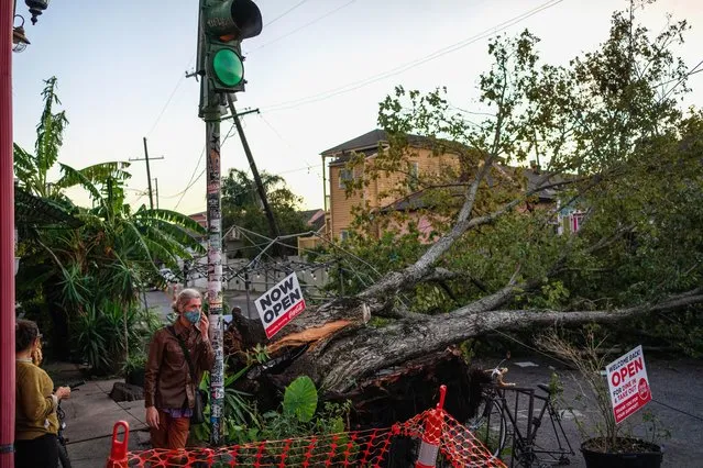 Olivia Mancing (L) and Zachery Quale talk outside of Flora Gallery and Coffee Shop near a downed tree in the street after Hurricane Zeta swept through New Orleans, Louisiana, U.S. October 29, 2020. (Photo by Kathleen Flynn/Reuters)
