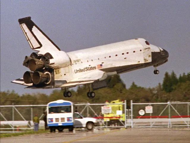 The Space Shuttle Columbia glides by rescue vehicles before touching down on Kennedy Space Center's Runway 33 early Saturday morning March 9, 1996 ending a 16-day mission. (Photo by Harold Crawford/AP Photo)