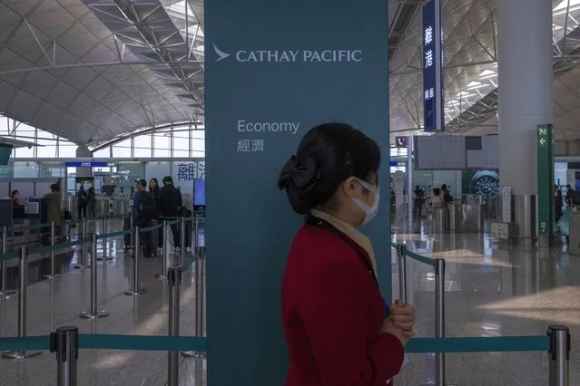 A Cathay Pacific Airways employee walks through the departures hall of Hong Kong International Airport in Hong Kong, on Wednesday, March. 8, 2023. (Photo by Louise Delmotte/AP Photo)