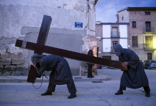 A penitent tied with a rope round the neck carries a cross during the “El Ensogado” (The roped) procession on Easter Holy Week's Maundy Thursday in the northern Spanish village of Sietamo on March 29, 2018. Christian believers around the world mark the Holy Week of Easter in celebration of the crucifixion and resurrection of Jesus Christ. (Photo by Ander Gillenea/AFP Photo)