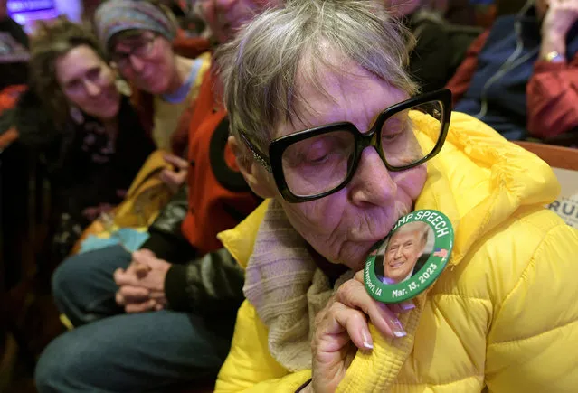Odelia Rogers, 81, kisses a button with a photo of former President Donald Trump before Trump speaks at a campaign event Monday, March 13, 2023, in Davenport, Iowa. (Photo by Ron Johnson/AP Photo)