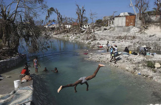 Locals wash clothes in Port Salut southwest of Port-au-Prince, on October 12, 2016, following the passage of Hurricane Matthew. A week after Matthew tore through the country, many remote areas communities were still left to their own devices. Families with destroyed homes and shattered livelihoods waited and prayed for help. (Photo by Rodrigo Arangua/AFP Photo)