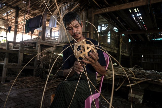 This photo taken on May 8, 2025 show a man weaving cane into a chinlone ball, used in the ancient Myanmar game considered a blend between sport and art, at a workshop in Hinthada township in the Irrawaddy delta region. Mastering control of the rising and falling rattan chinlone ball teaches patience, says a veteran of the traditional Myanmar sport – a quality dearly needed in the long-suffering nation. (Photo by Sai Aung Main/AFP Photo)
