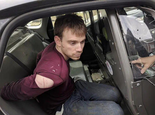 In this photo released by the Metro Nashville Police Department, Travis Reinking sits in a police car after being arrested in Nashville, Tenn., on Monday, April 23, 2018. Police said Reinking opened fire at a Waffle House early Sunday, killing at least four people. (Photo by Metro Nashville Police Department via AP Photo)