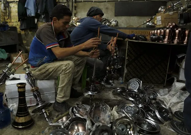 Workers are pictured at a shisha manufacturing factory in Baghdad December 17, 2014. (Photo by Thaier Al-Sudani/Reuters)