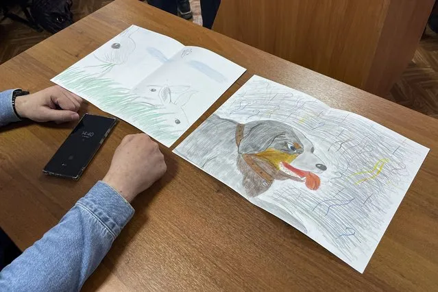 Moskalyov's lawyer Vladimir Biliyenko shows drawings that Maria Moskalyova, daughter of Alexei Moskalyov, drew for her father in a courtroom in Yefremov, Tula region, some 300 kilometers (186 miles) south of Moscow, Russia, Monday, March 27, 2023. A court in Russia on Tuesday convicted a single father over social media posts criticizing the war in Ukraine and sentenced him to two years in prison – a case brought to the attention of authorities by his daughter's drawings against the invasion at school, according to the man's lawyer and local activists. The 54-year-old Moskalyov, a single father of a 13-year-old daughter, was accused of repeatedly discrediting the Russian army, a criminal offense in accordance to a law Russian authorities adopted shortly after sending troops into Ukraine. (Photo by AP Photo/Stringer)