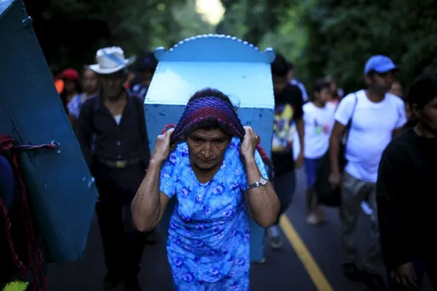 A woman carries the statue of Saint Christopher during a pilgrimage of Catholic devotees known as "Cumpas" in the town of Cuishnahuat, El Salvador November 26, 2015. (Photo by Jose Cabezas/Reuters)