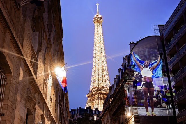 A photograph of Julien Alfred of Team Saint Lucia celebrating winning the gold medal during the Women's 100m Final  is projected as part of Parisienne Projections on August 03, 2024 in Paris, France. Parisienne Projections is a Getty Images project which displays the heroes and tragedies of 16 days of Olympic competition throughout the host city of Paris. (Photo by Carmen Mandato/Getty Images)