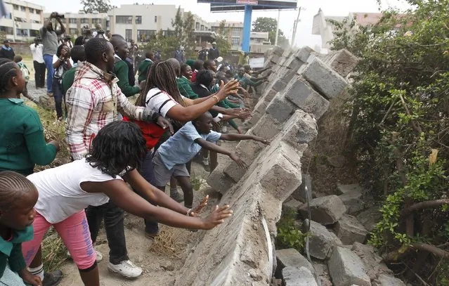Students from Langata primary school demolished a perimeter wall erected by a private developer around their school playground in Kenya's capital Nairobi, January 19, 2015. (Photo by Thomas Mukoya/Reuters)