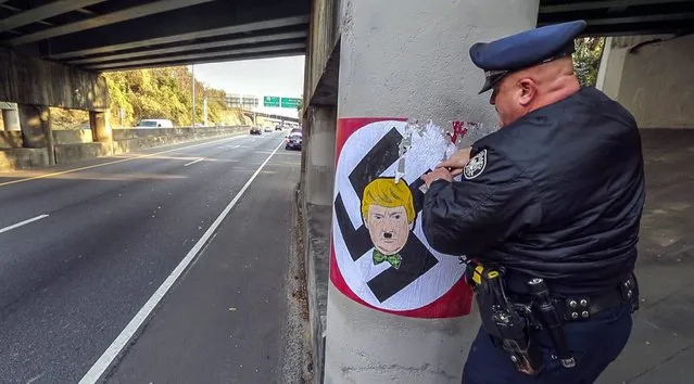 A photo provided by the Atlanta Journal-Constitution shows Atlanta police officer T. R. Coxe removing painted material of a large swastika featuring a likeness of Republican presidential candidate, Donald Trump, along the northbound Buford Highway Connector just south of the Piedmont exit, in Atlanta, Georgia, USA, 09 December 2015. Just days after Donald Trump's call to ban Muslims from entering the United States, someone painted large swastikas featuring the Republican presidential candidate's face on at least two northeast Atlanta bridge supports. (Photo by John Spink/EPA/AJC)