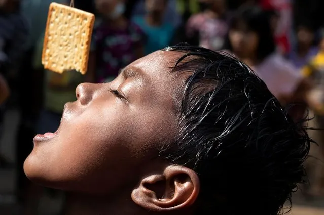 A boy takes part in a snack-eating contest during Myanmar's 73rd Independence Day celebrations amid the spread of the coronavirus disease (COVID-19) in Yangon, Myanmar, January 4, 2021. (Photo by Shwe Paw Mya Tin/Reuters)