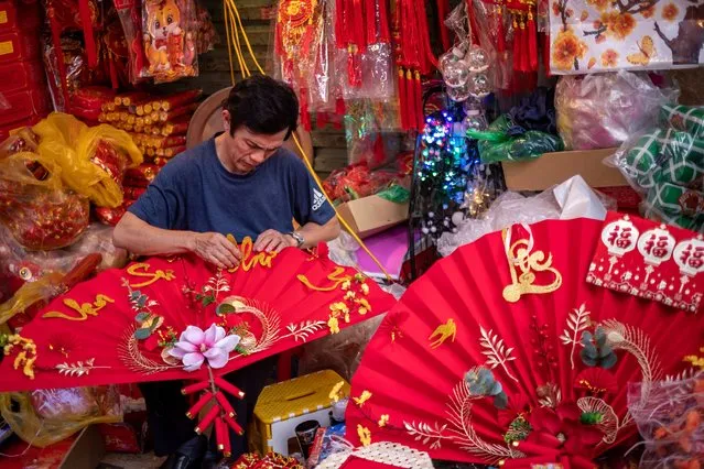 A vendor prepares his Lunar New Year decoration items at the Spring Festival Fair in the Old Quarter on January 14, 2023 in Hanoi, Vietnam. (Photo by Linh Pham/Getty Images)