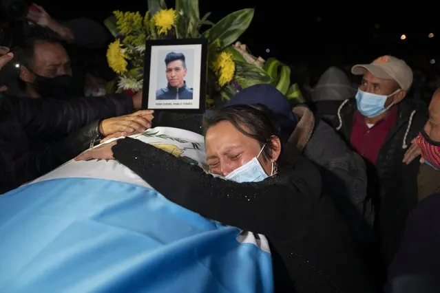 A relative grieves over the coffin containing the remains of Ivan Pablo Tomas, one of the Guatemalan migrants who was killed near the U.S.-Mexico border in January, at a memorial Mass in a soccer stadium in Comitancillo, Guatemala, Friday, March 12, 2021. The migrants were among 19 people shot and burned in Camargo, located in the northern Mexican state of Tamaulipas on Jan. 22. (Photo by Moises Castillo/AP Photo)