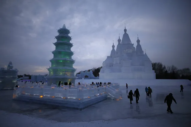 People walk around ice and snow sculptures ahead of the Harbin International Ice and Snow Festival in the northern city of Harbin, Heilongjiang province, China, January 5, 2016. (Photo by Aly Song/Reuters)