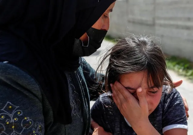 The daughter of Palestinian Osama Mansour is comforted as she mourns during her father's funeral in Biddu village, in the Israeli-occupied West Bank on April 6, 2021. (Photo by Mohamad Torokman/Reuters)