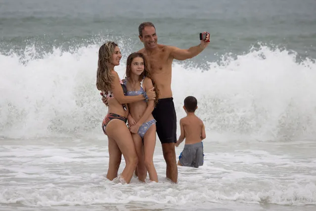 Oscar Volanos, of Spain, poses with his daughter Alexia, 12, and wife Isabel Garcia along the shoreline ahead of Hurricane Idalia in Clearwater Beach, Florida, U.S., August 29, 2023. (Photo by Adrees Latif/Reuters)