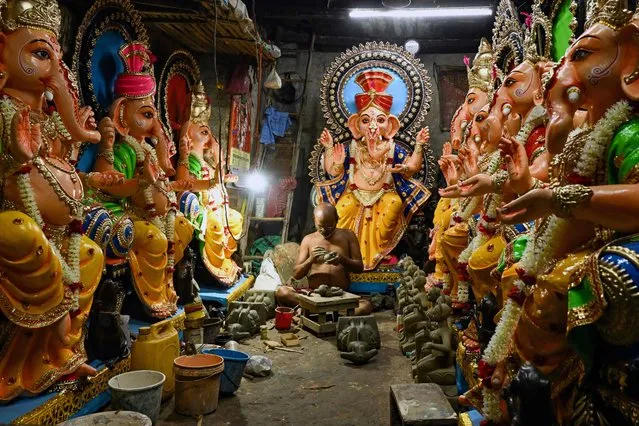 An artisan works on a clay idol of Hindu deity Ganesha ahead of the Ganesh Chaturthi festival at the craftsman’s village of Kumartoli in Kolkata on September 14, 2023. (Photo by Dibyangshu Sarkar/AFP Photo)