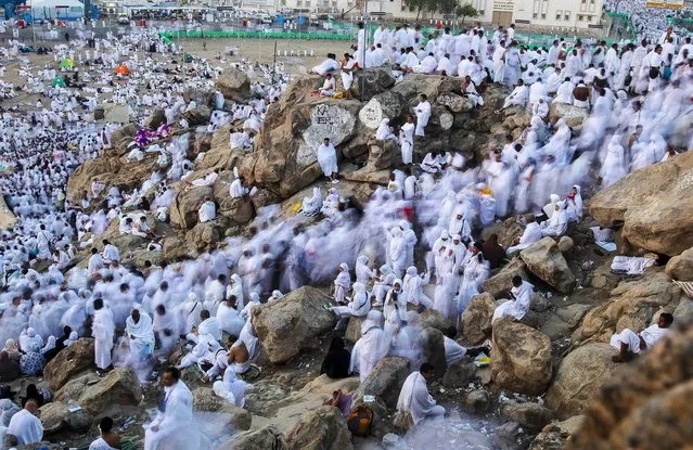 Muslim pilgrims gather atop Mount Mercy on the plains of Arafat during the peak of the annual haj pilgrimage, near the holy city of Mecca, on Oktober 14, 2013. An estimated two million Muslims were in Mecca, Saudi Arabia, on Monday morning for the start of the annual pilgrimage. (Photo by Ibraheem Abu Mustafa/Reuters)
