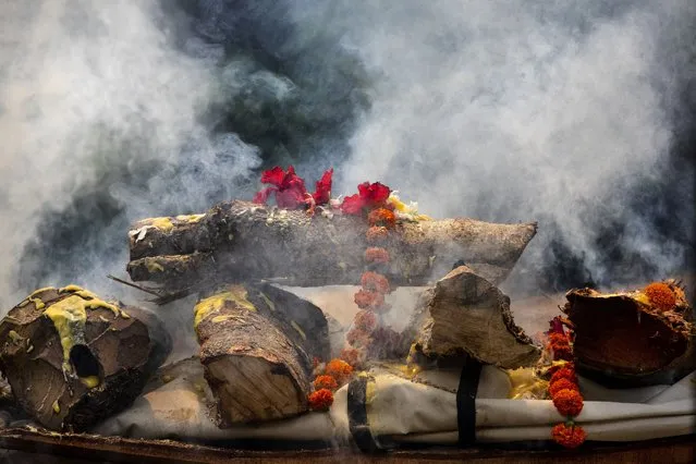 The body of a person who died of COVID-19 is cremated in Gauhati, India, Monday, May 24, 2021. (Photo by Anupam Nath/AP Photo)