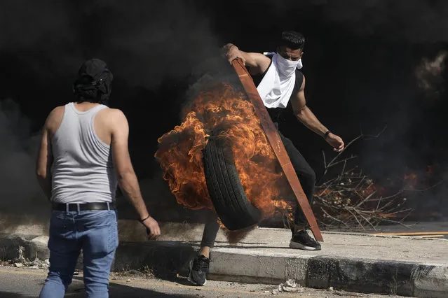 Palestinian demonstrators clash with Israeli forces following a demonstration in support of the Gaza Strip, in the West Bank city of Nablus, Friday, October 13, 2023. (Photo by Majdi Mohammed/AP Photo)