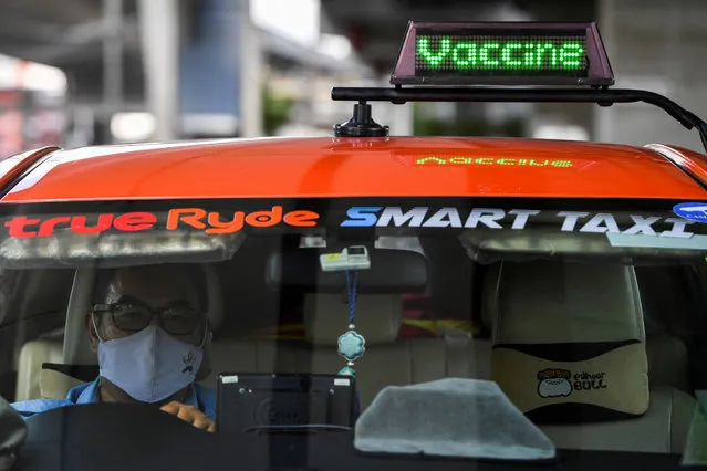 Thai taxi driver Sombat Subin rides with a sign above his cab showing that he has been vaccinated against the coronavirus disease (COVID-19) in order to attract more customers in Bangkok, Thailand, May 29, 2021. (Photo by Chalinee Thirasupa/Reuters)