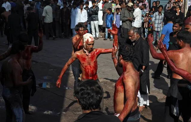 Indian Shiite Muslim flagellates themselves during a Muharram procession in Hyderabad, India, Friday, November 15, 2013. Shiite Muslims mark Ashura, the tenth day of the month of Muharram to commemorate the martyrdom Imam Hussein, a grandson of Prophet Muhammad, during the Battle of Karbala. (Photo by Mahesh Kumar A./AP Photo)