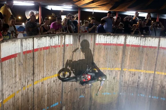 Motorcycle driver Zoran Milojkovic performs his stunt at the “Bozo Vukadinovic” wall of death in Belgrade, Serbia, 19 August 2022. Despite being a very popular attraction, the “Bozo Vukadinovic” is the last of its kind in the Balkan peninsula due to the high maintenance costs and low audience turnout. (Photo by Andrej Cukic/EPA/EFE)
