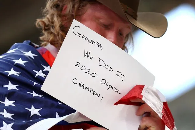 Ryan Crouser of the United States shows a message for his grandfather after winning gold in men's shot put at the Tokyo 2020 Olympic Games at the Olympic stadium in Tokyo on August 5, 2021. (Photo by Andrew Boyers/Reuters)