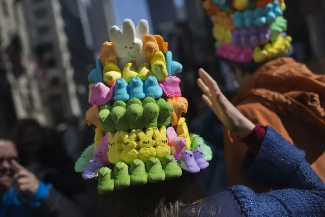 A woman steadies her hat made of marshmallow peeps as she makes her way along Fifth Avenue during the annual Easter Parade April 5, 2015 in New York City. The parade attracts hundreds of participants, many of whom don colorful hats and costumes to celebrate the Easter holiday. (Photo by Victor J. Blue/Getty Images)