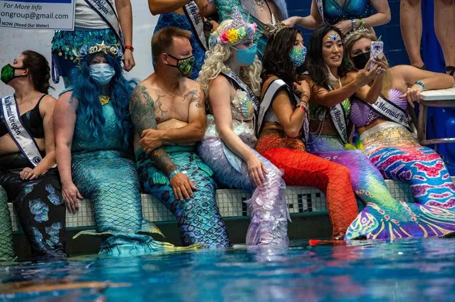 Mermaids and Mermen gather around the main pool for a group photo during MerMagic Con at the Freedom Aquatic Center in Manassas, Virginia on August 7, 2021. (Photo by Joseph Prezioso/AFP Photo)