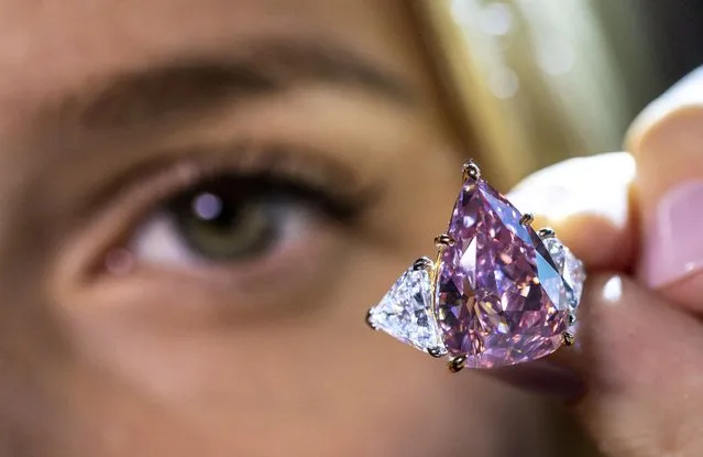 A model holds a 18,18 carat pink diamond called “Fortune Pink” that could fetch 30 million U.S. dollars during a preview at Christie’s before the auction sale in Geneva, Switzerland on November 2, 2022. (Photo by Denis Balibouse/Reuters)