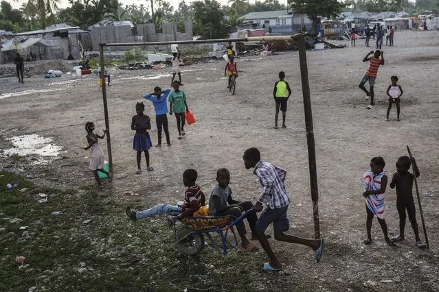 Children play in a field in Les Cayes, Haiti, Friday, August 20, 2021, six days after a 7.2 magnitude earthquake hit the area. (Photo by Matias Delacroix/AP Photo)