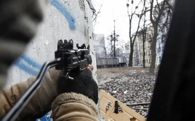 A pro-European integration protester aims his air gun towards riot police during clashes in Kiev, on January 20, 2014. (Photo by Vasily Fedosenko/Reuters)