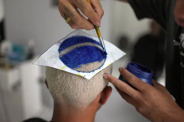 Manoel Silva waits to have the Brazilian flag design finished on his head, as a hairstyle created for the FIFA World Cup Qatar 2022 in Resende, Rio de Janeiro state, Brazil on December 6, 2022. (Photo by Pilar Olivares/Reuters)