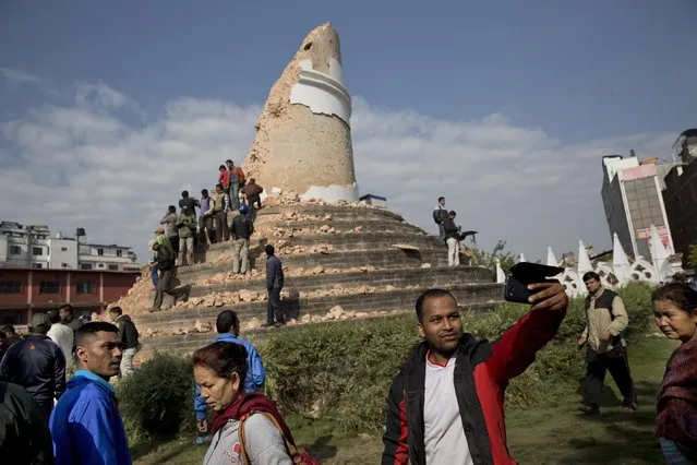 A man takes a selfie at the historic Dharahara Tower, a city landmark, that was damaged in Saturday's earthquake in Kathmandu, Nepal, Monday, April 27, 2015. A strong magnitude earthquake shook Nepal's capital and the densely populated Kathmandu valley on Saturday devastating the region and leaving tens of thousands shell-shocked and sleeping in streets. (Photo by Bernat Armangue/AP Photo)