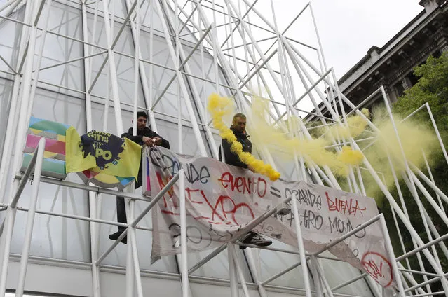 Demonstrators climb the Expo gate during a protest against Expo 2015 in Milan, Italy, Thursday, April 30, 2015. (Photo by Antonio Calanni/AP Photo)
