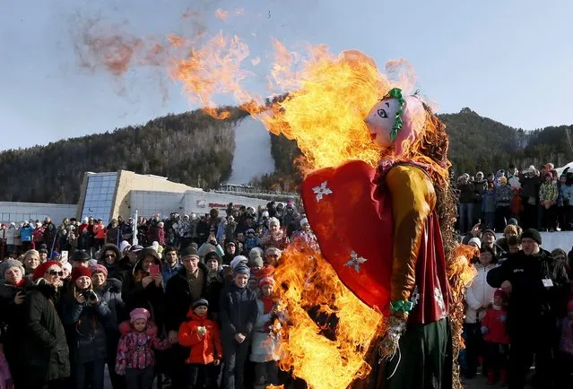 People burn an effigy of Lady Maslenitsa during Maslenitsa celebrations at the Bobrovy Log ski resort in the suburbs of Krasnoyarsk, Siberia, Russia, March 13, 2016. (Photo by Ilya Naymushin/Reuters)