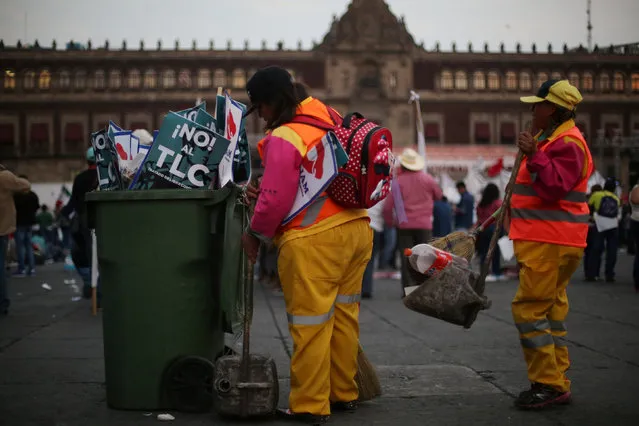Employees clean Zocalo Square as signs that read “No to TLC. Free Trade Agreement” are seen in a garbage bin after a protest against a fuel price hike in Mexico City, Mexico, January 31, 2017. (Photo by Edgard Garrido/Reuters)