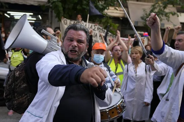 Healthcare workers shout slogans during a rally organized by their unions outside the Health Ministry in Athens, Thursday, October 21, 2021. Hundreds of Greek state hospital workers marched through central Athens as part of a 24-hour strike to protest staff shortages and compulsory coronavirus vaccinations. (Photo by Thanassis Stavrakis/AP Photo)